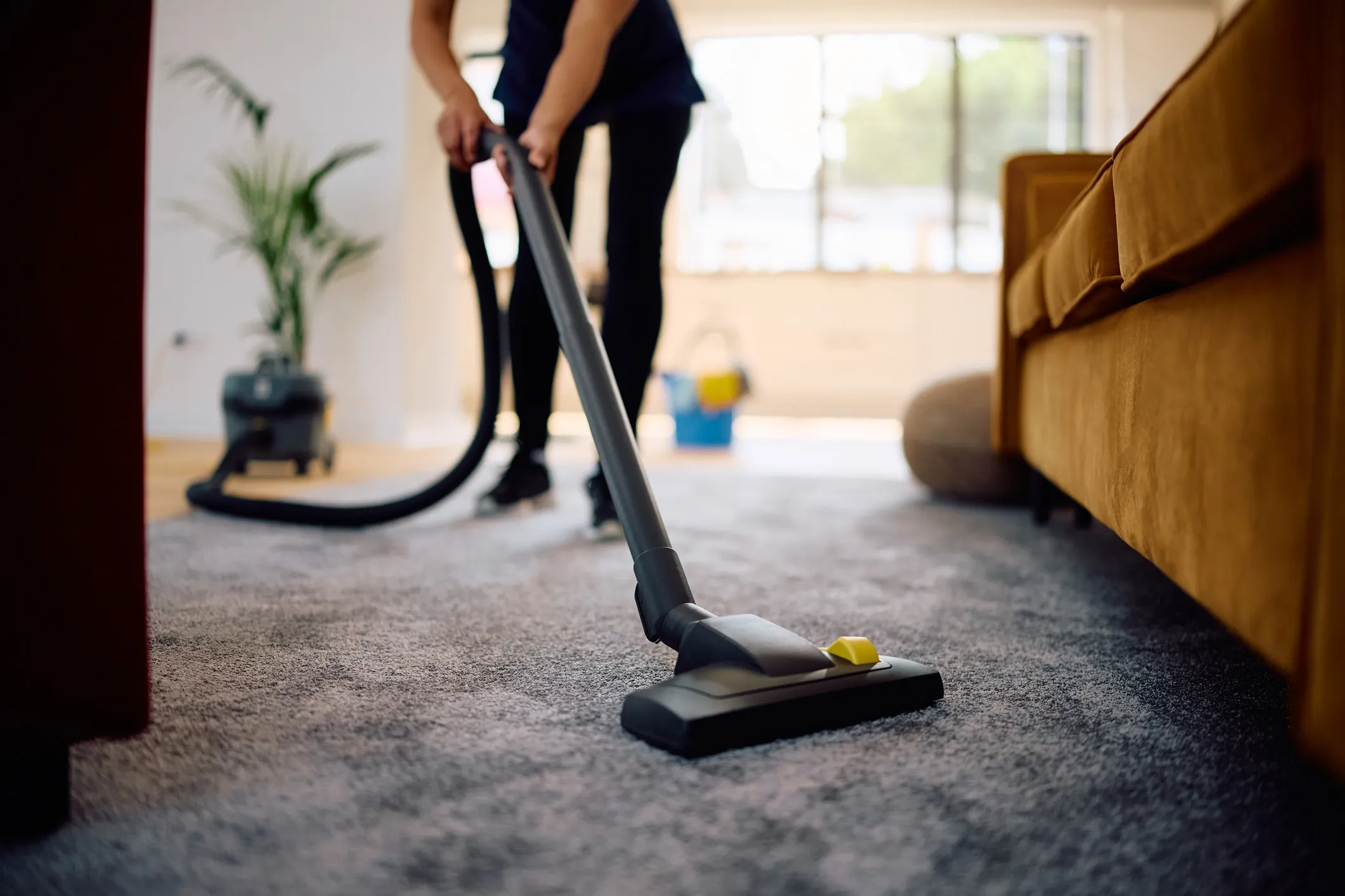 Person vacuuming carpet during a residential cleaning service